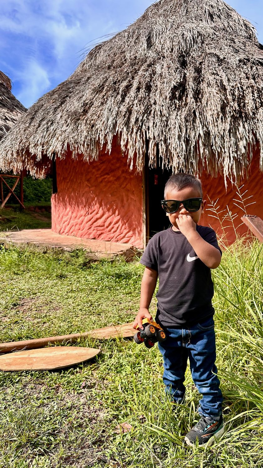 Niño frente a una casa tradicional